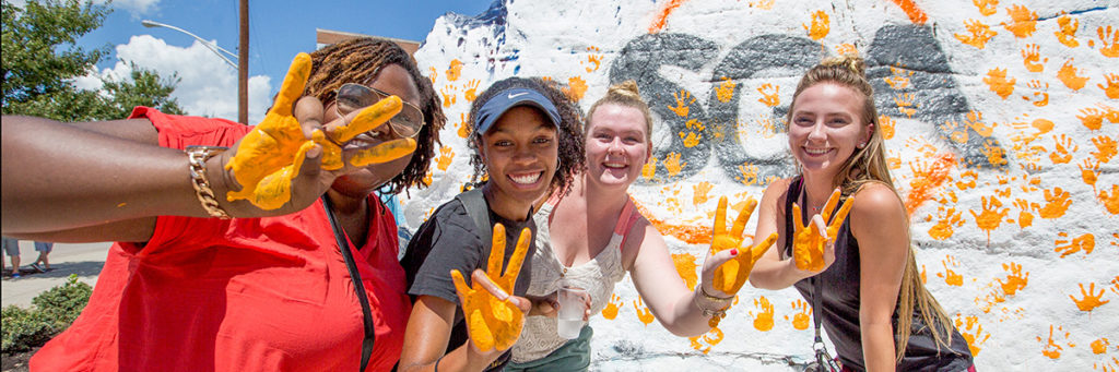 Students slap the rock during welcome week